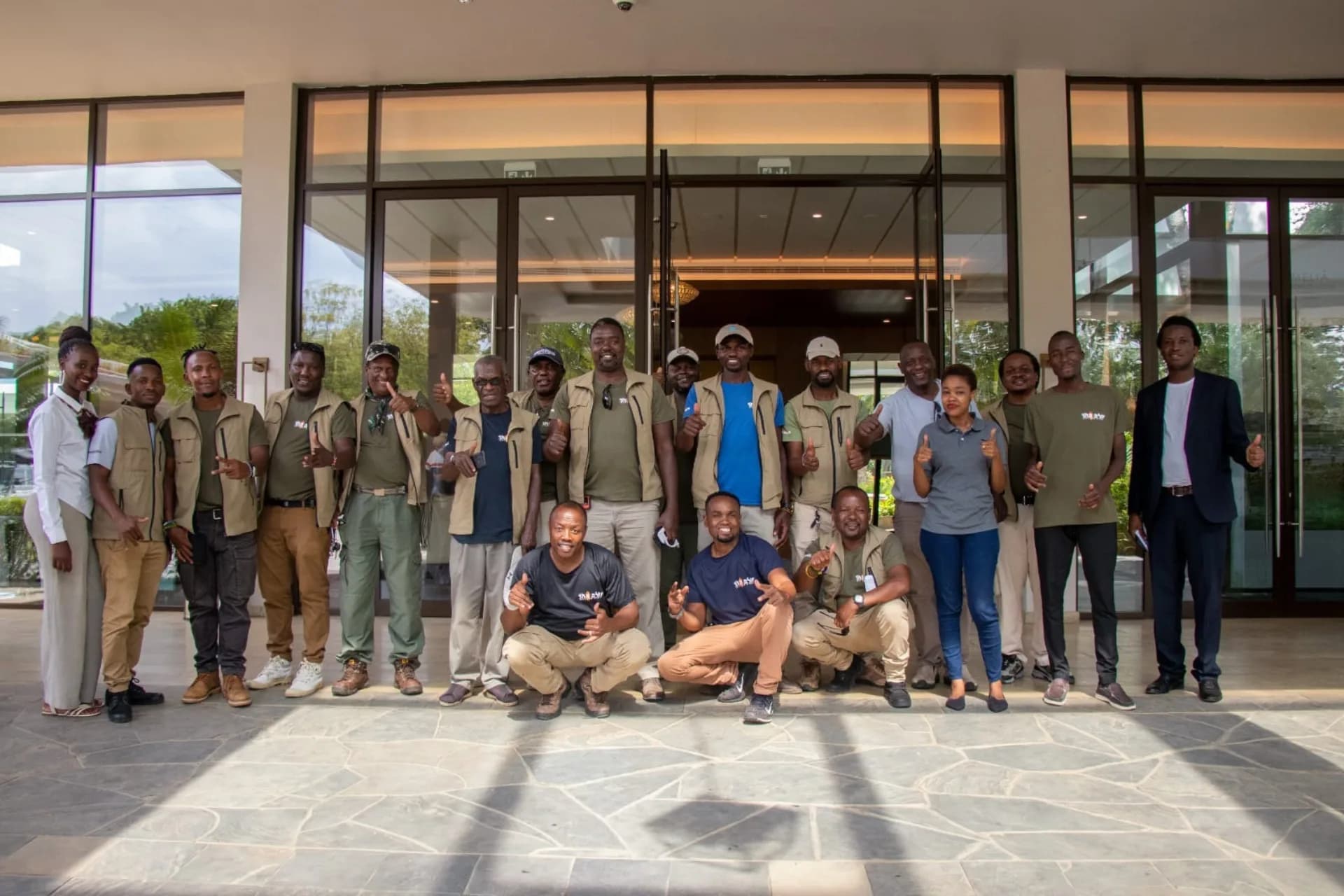 The full EXG Safaris team of guides and staff standing together in front of the Arusha office